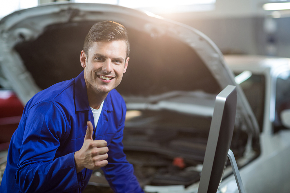 Portrait of mechanic showing thumbs up